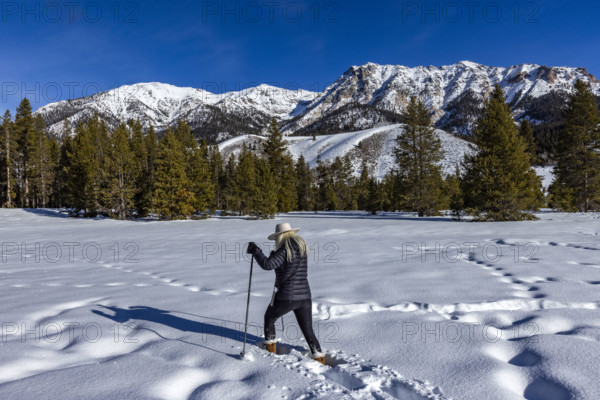 USA, Idaho, Sun Valley, Woman snowshoeing on sunny winter day