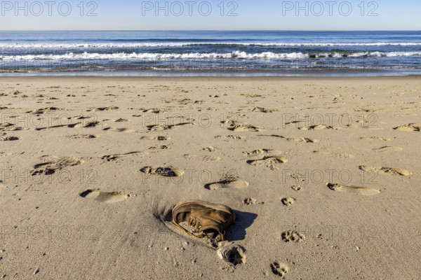 USA, California, Santa Monica, Abandoned boot and footprints on empty Santa Monica Beach
