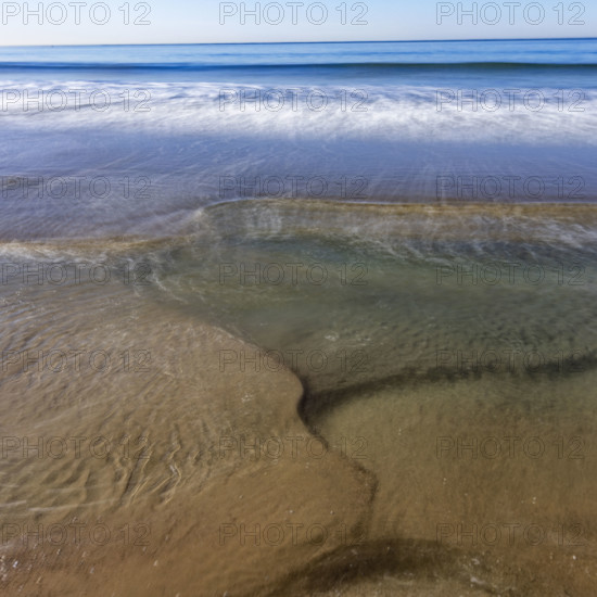 USA, California, Santa Monica, Motion blurred ocean waves on empty Santa Monica Beach
