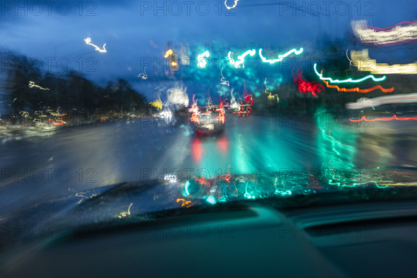 Traffic on road in rain at dusk seen from carmotion blur