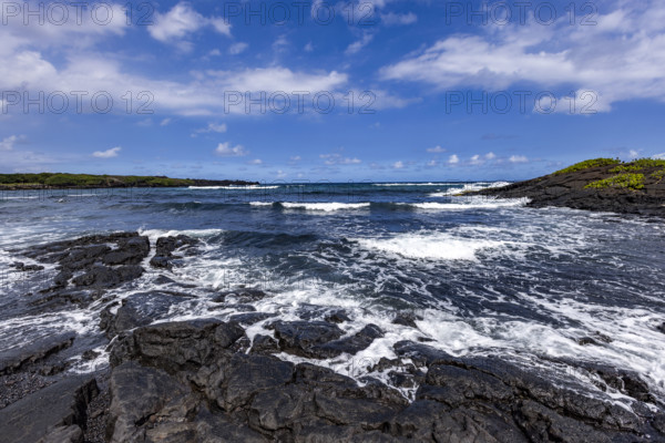 Motion blurred ocean waves washing coastal rocks. Kona, Hawaii, USA.