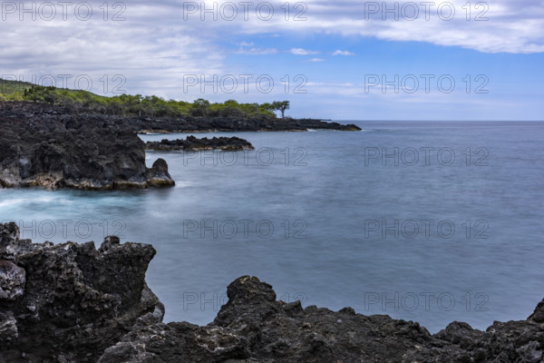 Motion blur ocean and rocky coastline. Kona, Hawaii, USA.