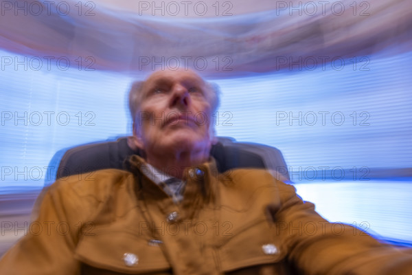 Senior man in desk chair, motion blurred. Bellevue, Idaho, USA.
