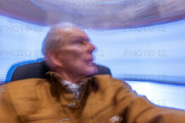 Senior man in desk chair, motion blurred. Bellevue, Idaho, USA.