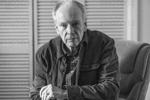 Portrait of senior man sitting in armchair, black and white. Boise, Idaho, USA.