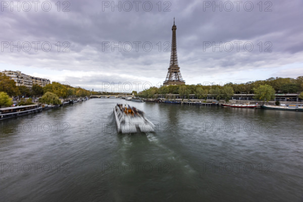 Sightseeing boat along Seine river with Eiffel Tower in background. Paris, Ile de France, France.