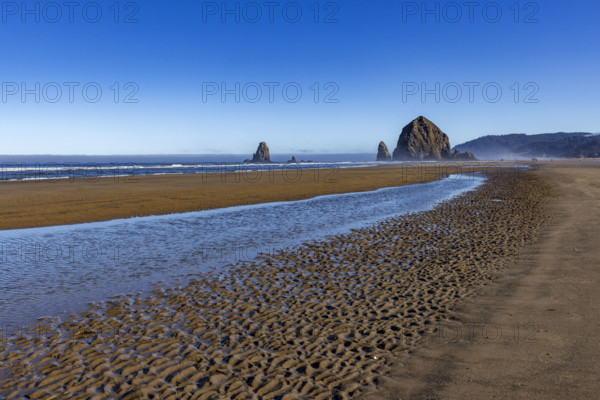 Cannon Beach at low tide with Haystack Rock in background. , Oregon, USA.