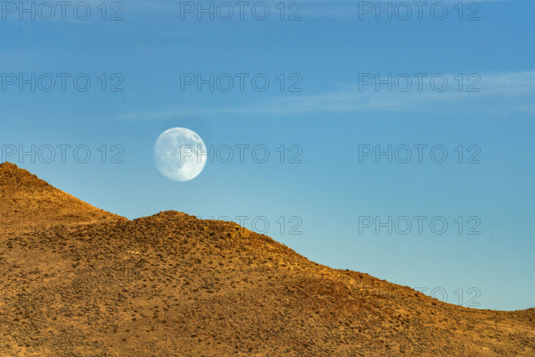 Moon rising over rocky hillside. Bellevue, Idaho, USA.