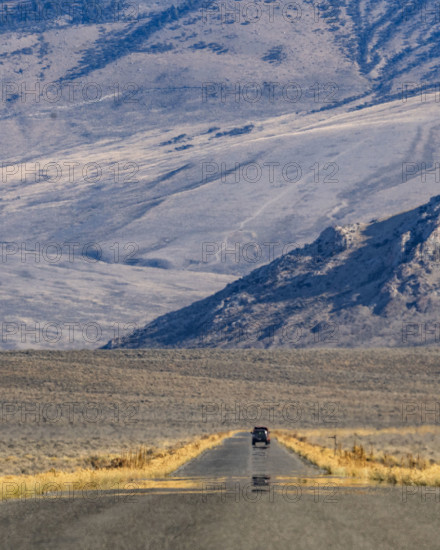 Lone vehicle on rural road over Trail Creek Pass. Mackay, Idaho, USA.