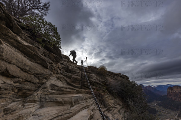 Low angle view of female hiker climbing top of Angels Landing. , Utah, USA.
