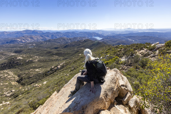 Senior blond hiker looking at view from top of Iron Mountain. Temecula, California, USA.
