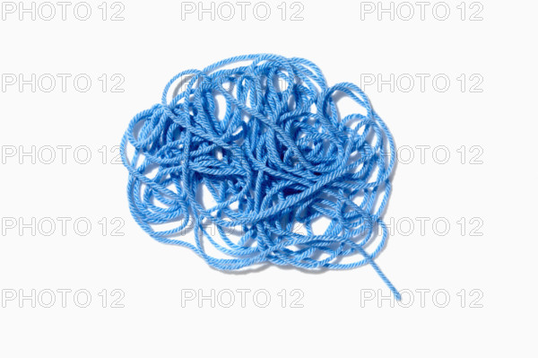 Tangled blue yarn on white background. New York City, New York State, USA.