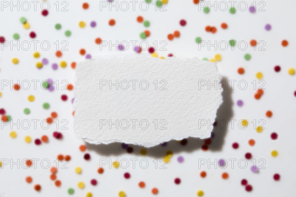 Torn white paper on confetti background. New York City, New York State, USA.