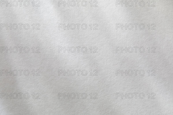 Dappled light on textured white paper. New York City, New York State, USA.