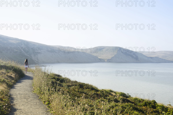 Rear view of woman on path at Drakes Bay, Inverness, California, USA.