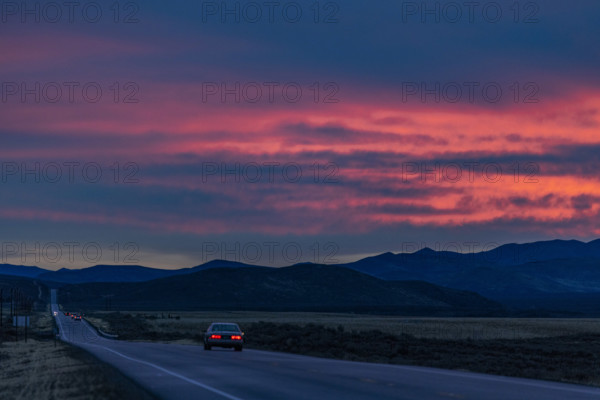 Car on highway 20 at sunrise, Belleuve, Idaho, USA.