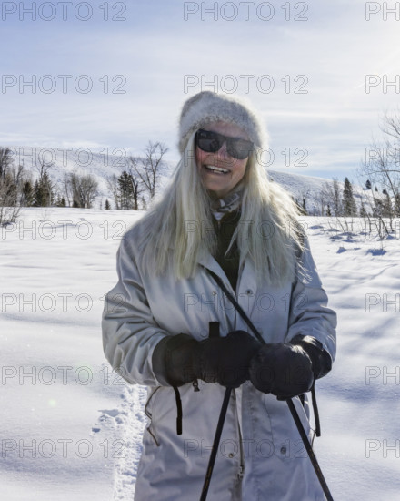 Portrait of smiling senior woman in snowy landscape, Sun Valley, Idaho, USA.