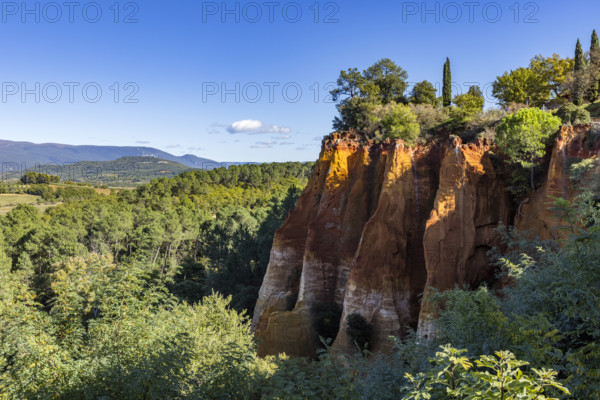 Ochre-colored cliffs on sunny day, Roussillon, Vaucluse, France.