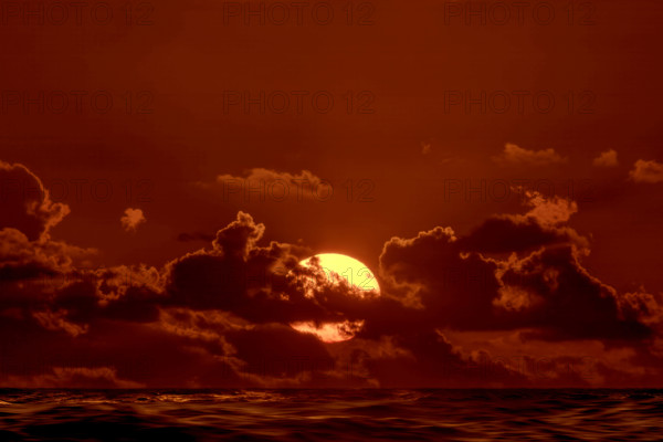 Sun rising through clouds over Atlantic Ocean, Boca Raton, Florida, USA.