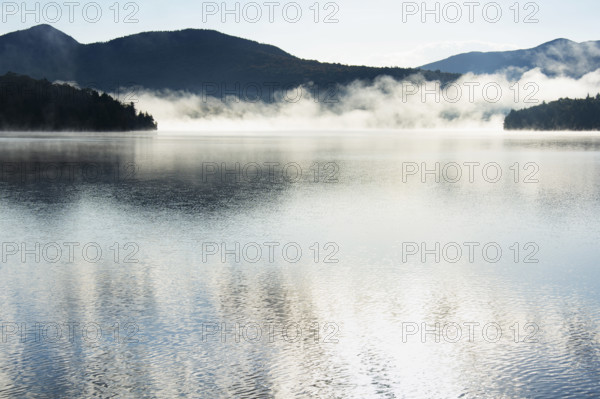 Autumn mist rising on Lake Placid, Lake Placid, New York, USA.
