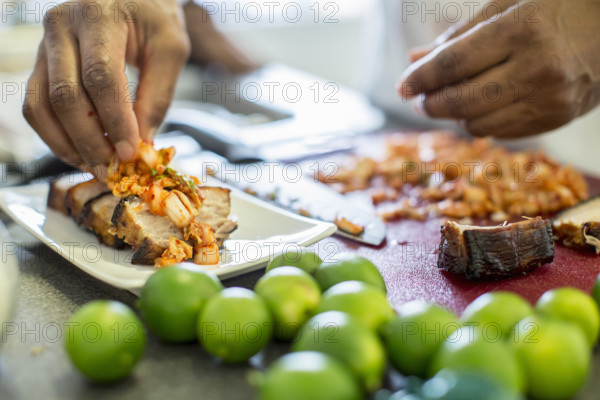 Close-up of chef making pork belly and kimchee in restaurant, Los Angeles, California, USA.