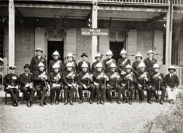 Officers of the Mauritius Police Headquarters. Uniformed ranking officers of the Mauritius Police Headquarters pose for the camera outside Line Barracks. Port Louis, Maurititus, circa 1932. Mauritius, Indian Ocean, Africa.