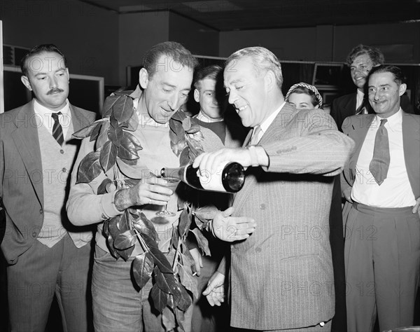 Manussis and Heather-Hayes return. Celebration drink for racing drivers John Manussis and Jim Heather-Hayes who have just returned from a Morris Minor record attempt trip. Kenya, 6 September 1954. Kenya, Eastern Africa, Africa.