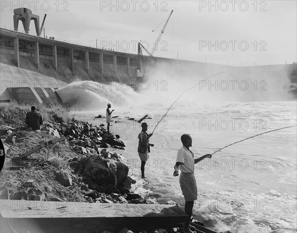 Fishing at the Owen Falls Dam. Men fishing at the site of the brand new Owen Falls Dam (Nalubaale Dam) across the White Nile River, the construction of which was completed in 1954. Near Jinja, Eastern Region, Uganda, 12 October 1954., East (Uganda), Uganda, Eastern Africa, Africa.