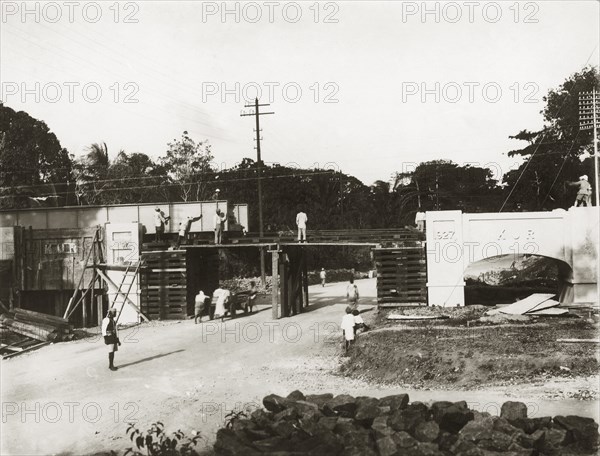 Building a rail bridge. A rail bridge under construction on the Kilindini-Mombasa road. The bridge's construction was overseen by Parlane Macfarlane, a senior British employee of the Kenya & Uganda Railways. The date '1927' is engraved on one of the masonry pylons. Mombasa, Kenya, 1927. Mombasa, Coast, Kenya, Eastern Africa, Africa.