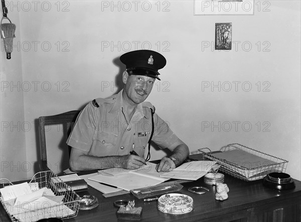 Jasper Maskelyne. Jasper Maskelyne as a Kenyan Police officer. The shoulder epaulettes on his uniform read 'KENYA POLICE' and his shirt displays numerous military medals. Kenya, 24 February 1953. Kenya, Eastern Africa, Africa.