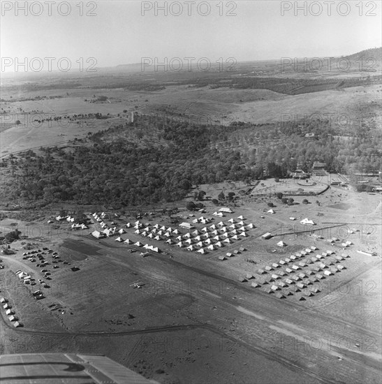 Kenya Regiment camp. A Kenya Regiment camp as seen from above. Tents pitched in grid formation and parading soldiers are visible on the ground. The Kenya Regiment, a voluntary territorial force, was established in 1937 in the name of King George VI. Kenya, 20-28 March 1953. Kenya, Eastern Africa, Africa.