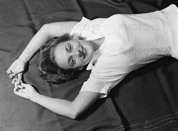 Cecily reclining. Cecily Gaueghan posing for a studio-style portrait. Kenya, 28 April 1953. Kenya, Eastern Africa, Africa.