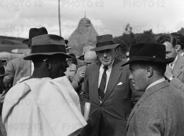 Littleton and Chief Makimei. A Western official identified as 'Littleton' talks to Chief Makemei in a crowded meeting place. Kenya, 16 May 1953. Kenya, Eastern Africa, Africa.