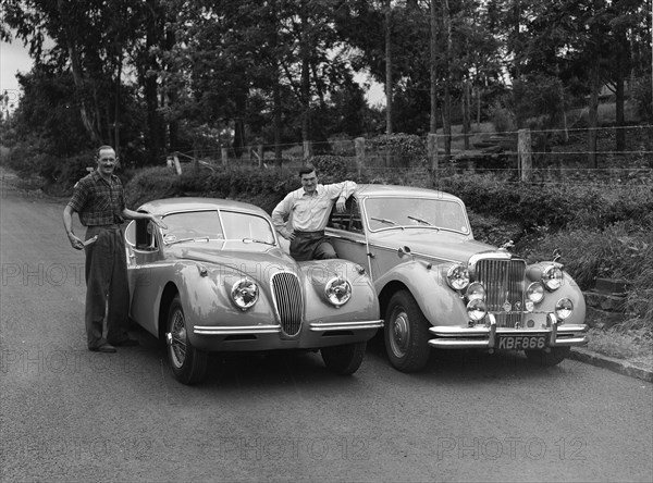 Men with motors. Proud car owners Peter Knight (left) and Archer (right), pose with their respective vehicles, a Jaguar Coupe and a Jaguar Mark V. Kenya, 7 June 1953. Kenya, Eastern Africa, Africa.