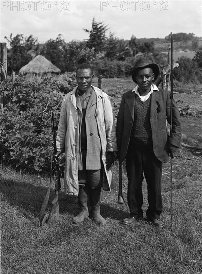 Uplands home guards. Two home guards, one armed with a rifle, the other with a club and spear. The home guard in this area consisted of Kikuyu government loyalists who independently formed militia groups to support the other British security forces present in Kenya at this time. Kenya, June 1953. Kenya, Eastern Africa, Africa.