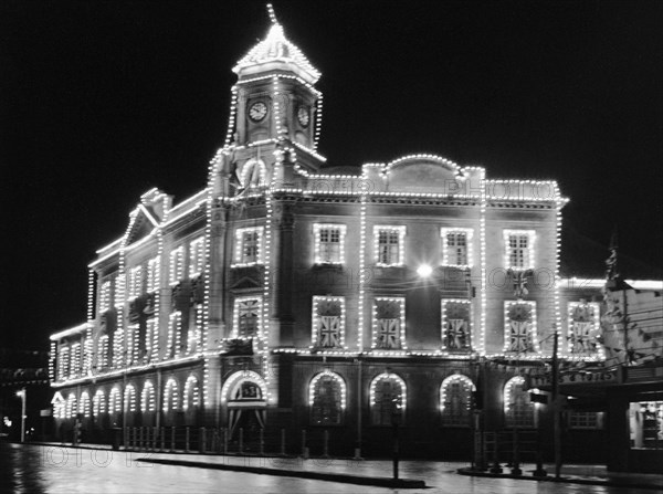 Khoja Mosque. The Khoja mosque, on the corner of Government Road (now Moi Avenue) and Swamp Road, illuminated with strings of electric lights and festooned with union jack flags. Nairobi, Kenya, circa 1956.