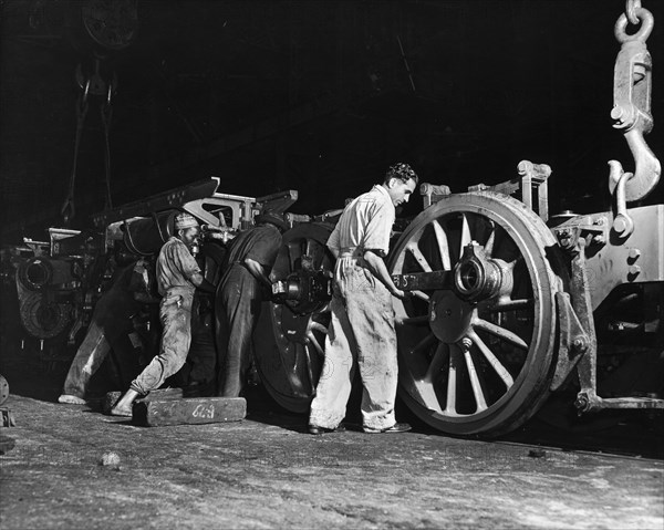 Locomotive workshop in Nairobi. A publicity photograph illustrating the multiracial nature of the workforce in the locomotive workshop of the East African Railways and Harbours Administration (EAR&H). A European, a Sikh and an African work together on a railway bogie. Nairobi, Kenya, circa 1960. Nairobi, Nairobi Area, Kenya, Eastern Africa, Africa.