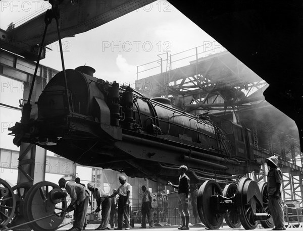 Assembling a locomotive. A publicity photograph from the East African Railways and Harbours Administration (EAR&H) showing the lowering of a locomotive boiler onto bogies in the workshops at Nairobi. Nairobi, Kenya, circa 1960. Nairobi, Nairobi Area, Kenya, Eastern Africa, Africa.
