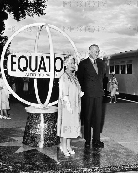 The Queen Mother visits Kenya. A publicity photograph from the East African Railways and Harbours Administration (EAR&H). Queen Elizabeth, the Queen Mother, poses for cameras with Sir Evelyn Baring, the Governor of Kenya, at the monument near Maji Mazuri in the Kenyan highlands marking the Equator. Central Kenya, 12 February 1959., Central (Kenya), Kenya, Eastern Africa, Africa.