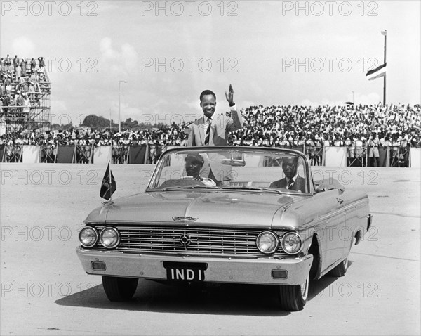 Julius Nyerere greets crowds. A publicity photograph from the East African Railways and Harbours Administration (Ear&H) showing Dr Julius Nyerere, the first leader of independent Tanganyika, waving to a crowded arena from the back of an open-topped car. Tanganyika (Tanzania), circa 1961. Tanzania, Eastern Africa, Africa.