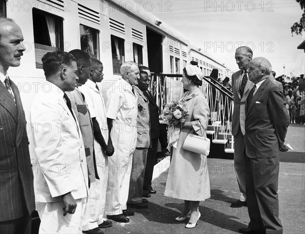 The Queen Mother greets a train driver. A publicity photograph from the East African Railways and Harbours Administration (EAR&H). Queen Elizabeth, mother of Queen Elizabeth II, greets Peter Harrison, the driver of the royal train, and other railway staff. Nakuru, Kenya, 12 February 1959. Nakuru, Rift Valley, Kenya, Eastern Africa, Africa.