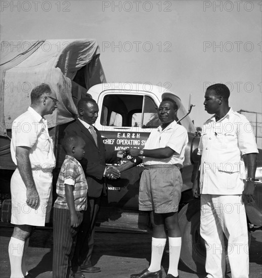 Handing over keys to a truck. A publicity photograph from the East African Railways and Harbours Administration (EAR&H) showing an African official of EAR&H handing over the keys to a freight truck in its road transport division to its new driver. Mombasa, Kenya, circa 1960. Mombasa, Coast, Kenya, Eastern Africa, Africa.
