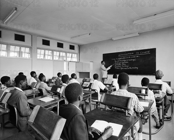 Class in a railway training school. A publicity photograph from the East African Railways and Harbours Administration (EAR&H) showing pupils at their desks in a classroom of the railway training school. There is at least one Sikh student in a class of young African men and their teacher is European. Nairobi, Kenya, circa 1960. Nairobi, Nairobi Area, Kenya, Eastern Africa, Africa.