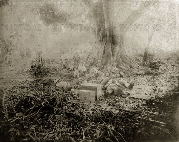 The effects of a heavy lunch. Indian and British men from a big game hunting party lie slumped beneath a large tree after having eaten a heavy lunch. Cooch Behar, India, 1889. Cooch Behar, West Bengal, India, Southern Asia, Asia.