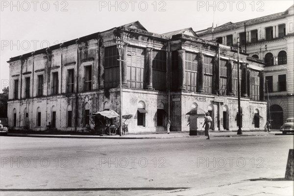Sydney Webster's building. A delapidated building identified as 'Sydney Webster's building (taken) from S.W. British Embassy right corner'. A sign above the main entrance reads: 'Sydney Webster & Co.', whilst other painted signs around the building read: 'Exide Service Station'. Possibly Rangoon (Yangon), Burma (Myanmar), circa 1910. Yangon, Yangon, Burma (Myanmar), South East Asia, Asia.