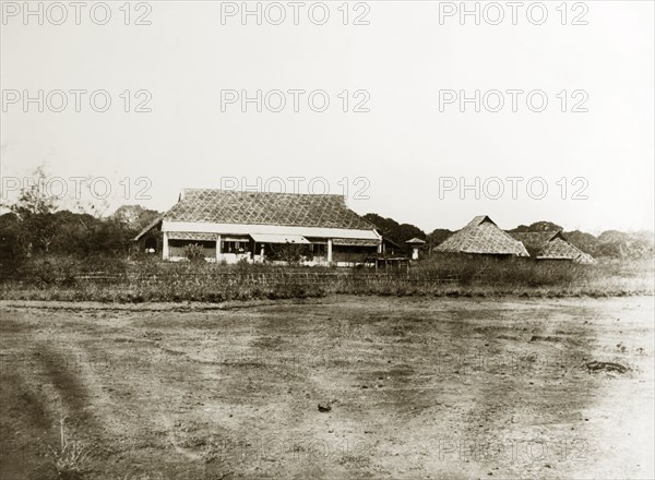 Burmese dwellings. A row of single-storey, thatched roof dwellings. Burma (Myanmar), circa 1910. India, Southern Asia, Asia.