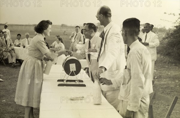 Mrs Lawson takes third prize. A delighted Mrs Natalie Lawson receives a bottle of whisky as third prize in a raffle at the Rangoon Golf Club. Rangoon (Yangon), Burma (Myanmar), circa 1952.


at the raffle at the Burma Open Championship. Rangoon, Burma, 1952. Yangon, Yangon, Burma (Myanmar), South East Asia, Asia.