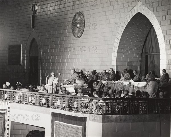 Addressing the sixth Buddhist Synod. One of several Buddhist monks, seated on a raised balcony, addresses the congregation during the sixth Buddhist Synod at Rangoon. Rangoon (Yangon), Burma (Myanmar), 1954. Yangon, Yangon, Burma (Myanmar), South East Asia, Asia.