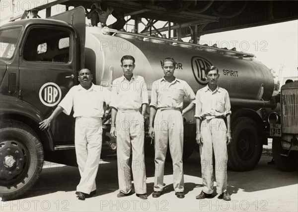 Indo-Burma Petroleum Company tanker. Four uniformed Burmese workers pose for a photograph in front of an Indo-Burma Petroleum Company petrol tanker. Burma (Myanmar), circa 1942. Burma (Myanmar), South East Asia, Asia.