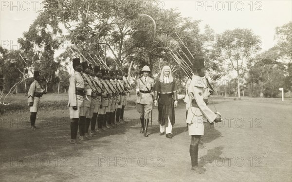 Judge Clifford Francis inspects the King's African Rifles. Judge Clifford Francis is accompanied by a British army officer as he inspects a line up of the King's African Rifles. Uganda, March 1936. Uganda, Central Africa, Asia.